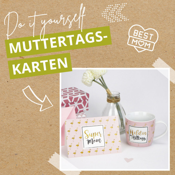 Eine selbst gebastelte Muttertagskarte mit einer rosafarbenen Karte mit der Aufschrift "Super Mom", einer Tasse mit der Aufschrift "Heldin des Alltags", weißen Blumen in einem Glasgefäß und einer rosafarbenen, gemusterten Geschenkbox auf einem Hintergrund aus Kraftpapier.
