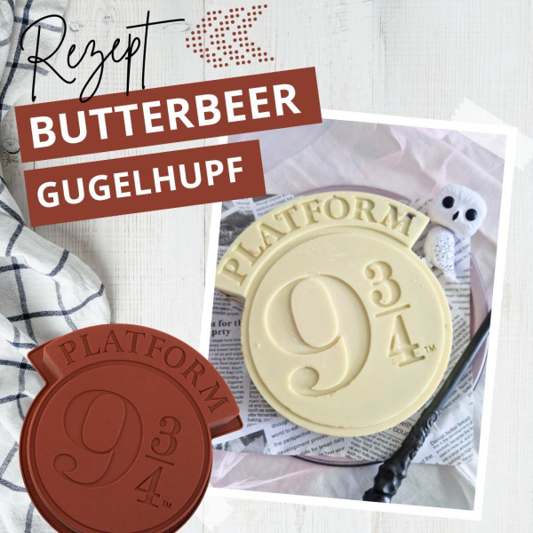 Ein weißer Schokoladenkuchen in Form des Bahnsteig 9¾-Zeichens steht auf einem Tisch mit einem gestreiften Tuch, einem Zauberstab und einem kleinen weißen Eulenplüsch. Der Text lautet "Rezept Butterbier Gugelhupf". Ein Bahnsteig 9¾-Schild aus Schokolade ist ebenfalls abgebildet.